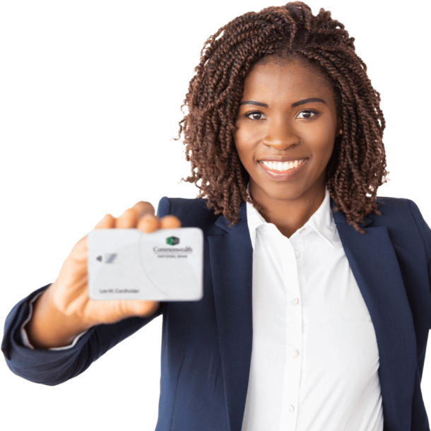 A smiling Black woman in a blue suit is holding up a Commonwealth Bank debit card.