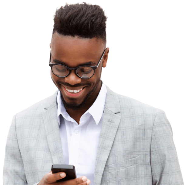 A smiling Black man is holding and looking at his smartphone.