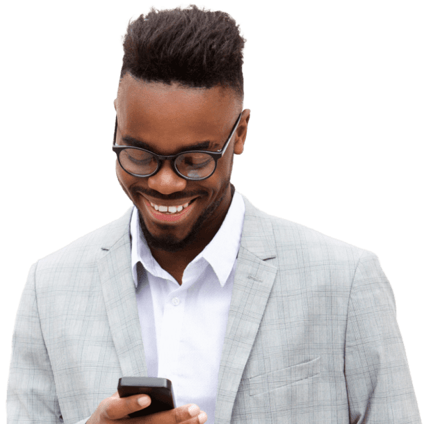A smiling Black man is holding and looking at his smartphone.