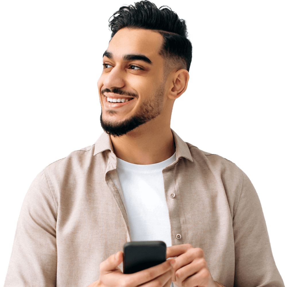 A smiling man is holding a smart phone and looking to his right.